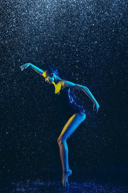 Two young female ballet dancers under water drops