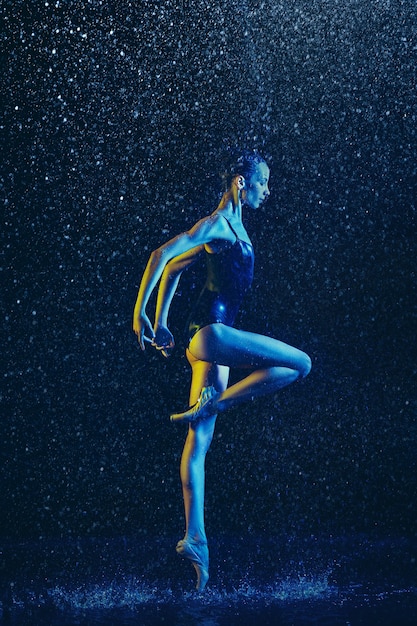 Two young female ballet dancers under water drops