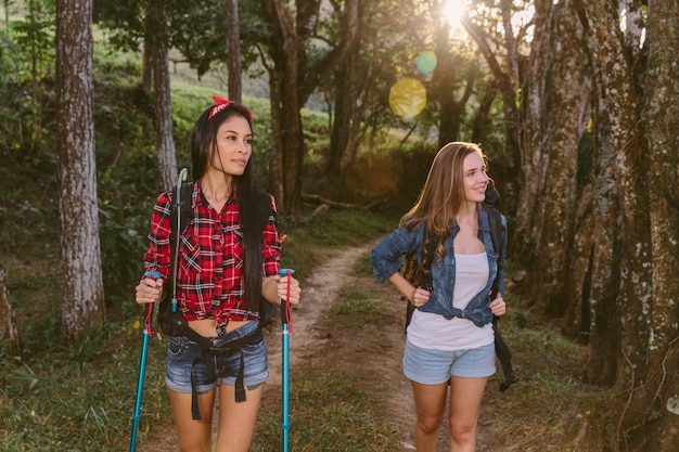 Two young female friends hiking in forest