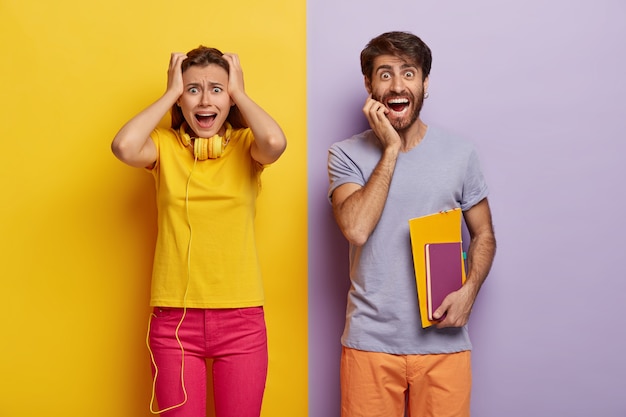 Две молодые девушки и мужчины возвращаются к учебе, женщина в панике смотрит, держит обе руки на голове, носит желтую футболку и розовые брюки, веселый парень несет блокноты для письма