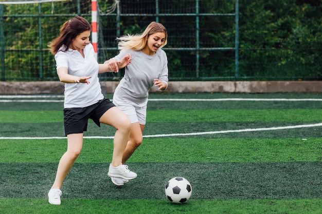 Free photo two young female soccer players on the field