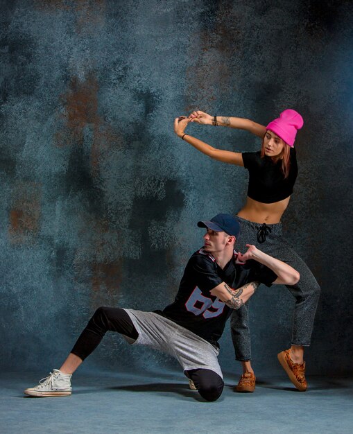 The two young girl and boy dancing hip hop in the studio