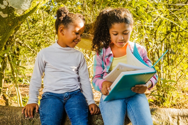 Two young girls reading together