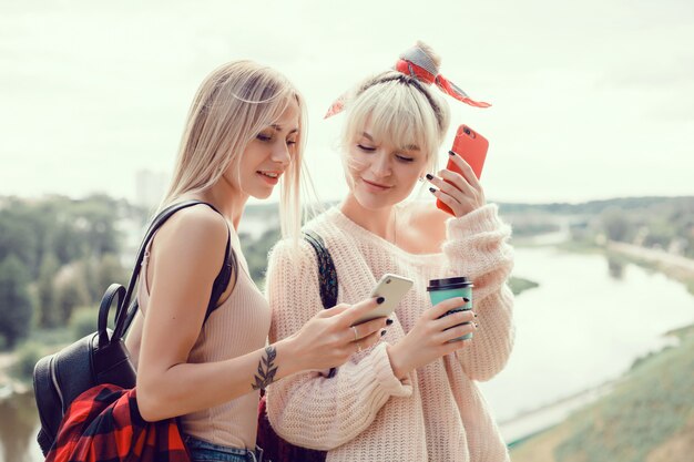 Two young girls sisters posing on the street, make selfie