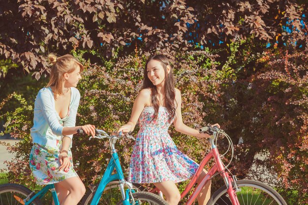 公園で自転車を持つ2人の若い女の子