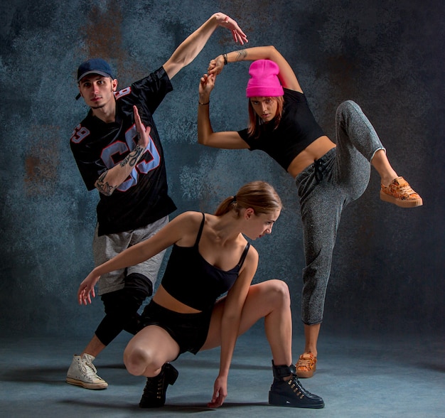 Free photo two young girsl and boy dancing hip hop in