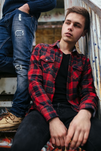 Free photo two young guys stand in an abandoned building on the stairs