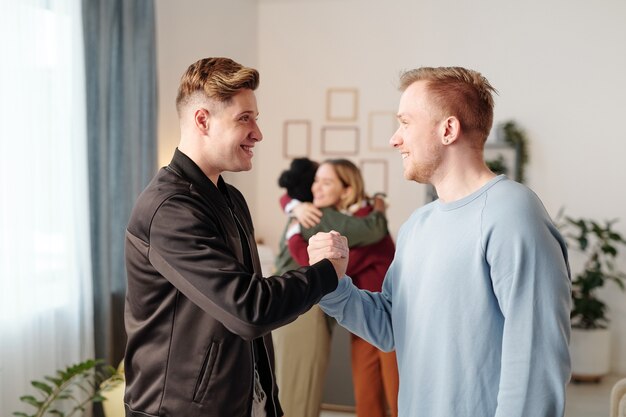 Premium Photo | Two young happy men in casualwear standing ...