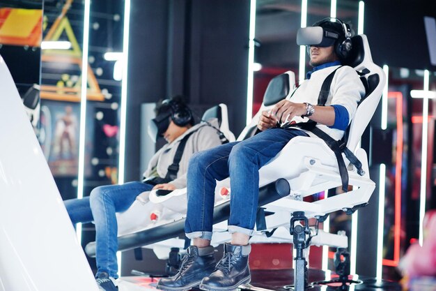 Two young indian people having fun with a new technology of a vr headset at virtual reality simulator