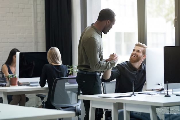 Two young male colleagues discussing new startup project