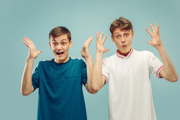 Two young men standing in sportwear isolated on blue