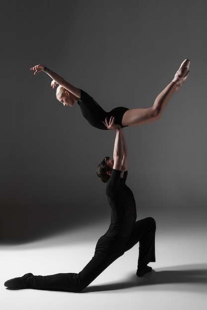 Two young modern ballet dancers on gray