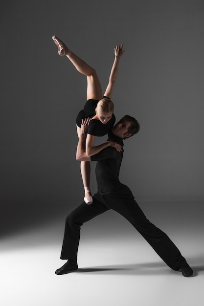 Two young modern ballet dancers on gray