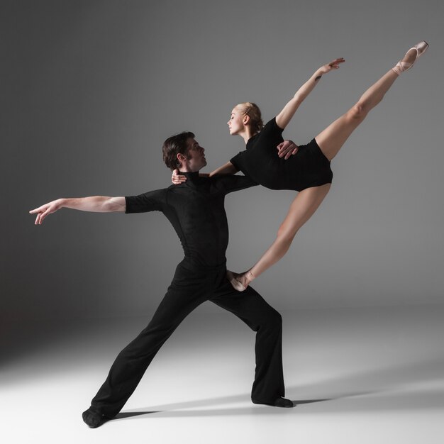 Two young modern ballet dancers on gray