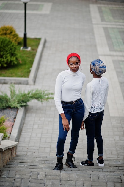 Foto gratuita due giovani donne musulmane africane attraenti moderne alla moda alte e magre in hijab o sciarpa a turbante poste insieme