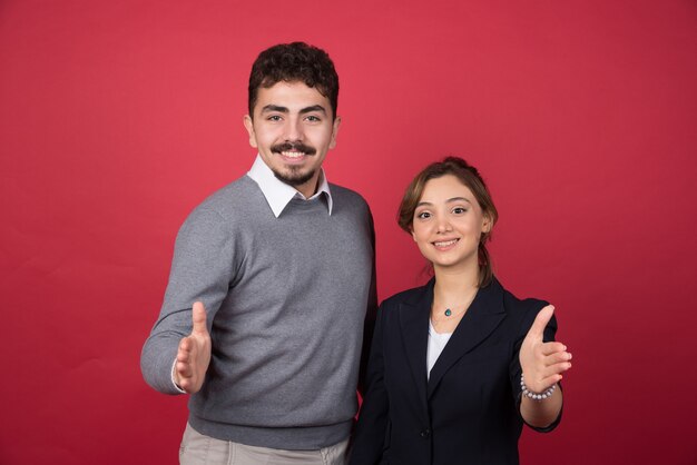 握手のために手を差し伸べる2人の若いサラリーマン