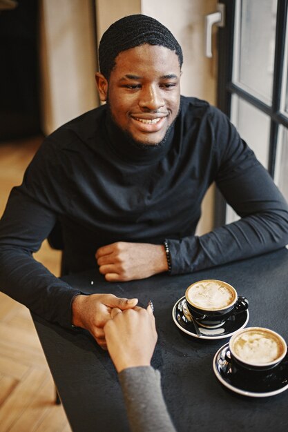 Two young people in cafe. African couple enjoying the time spending with each other.