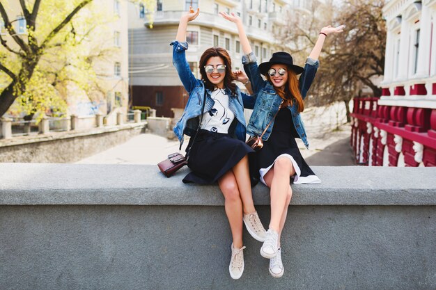 Two young pretty friends womans having fun outdoor on the street