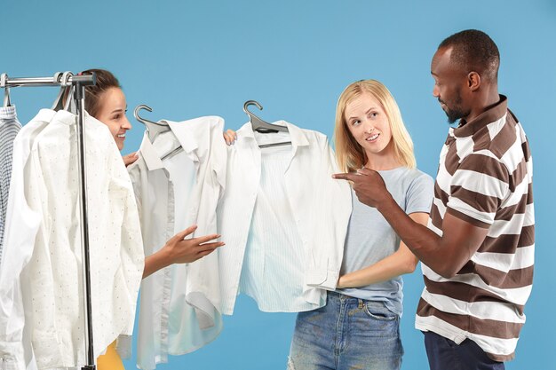 The two young pretty girls looking at dresses and try on it while choosing at shop