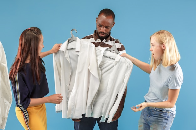 The two young pretty girls looking at dresses and try on it while choosing at shop