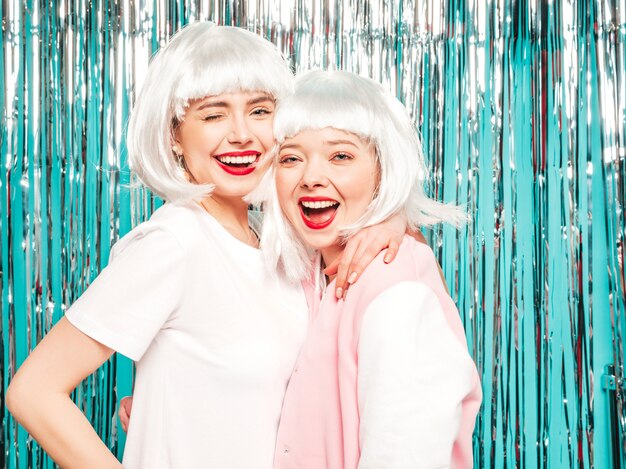 Two young sexy smiling hipster girls in white wigs and red lips.Beautiful trendy women in summer clothes summer 