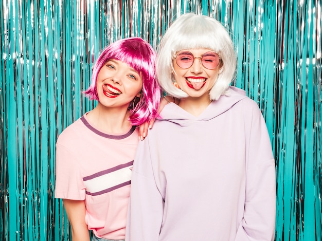 Two young sexy smiling hipster girls in white wigs and red lips.Beautiful trendy women in summer clothes