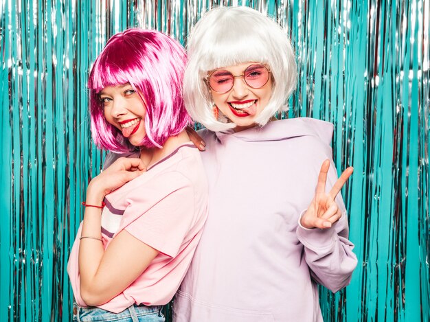 Two young sexy smiling hipster girls in white wigs and red lips.Beautiful trendy women in summer clothes