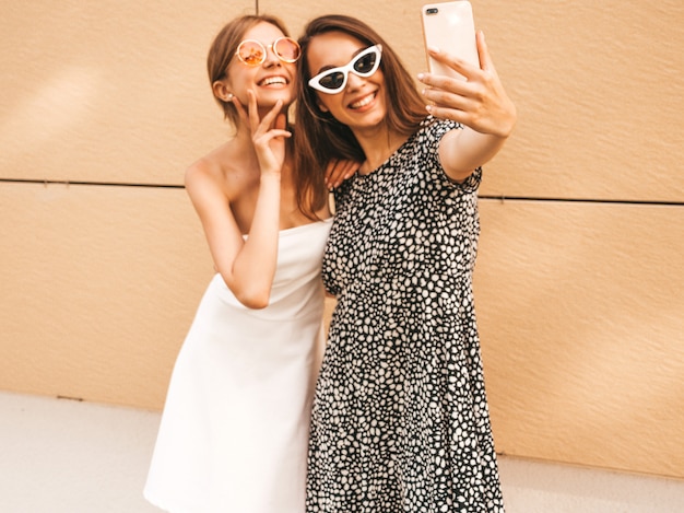Two young smiling hipster women in summer clothes.