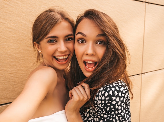 여름 옷에 두 젊은 미소 hipster 여자.