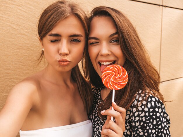 Two young smiling hipster women in summer clothes.