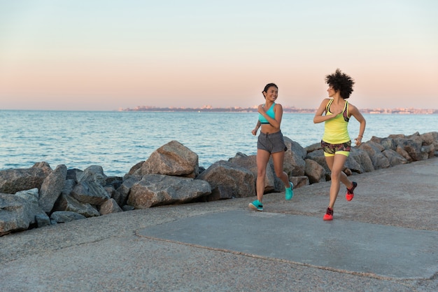 Two young sportswomen running together and talking