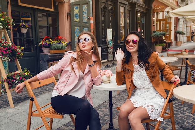 Two young stylish women sitting at cafe