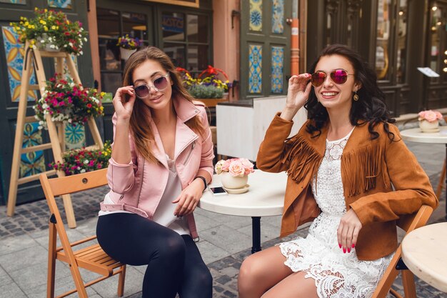 Two young stylish women sitting at cafe