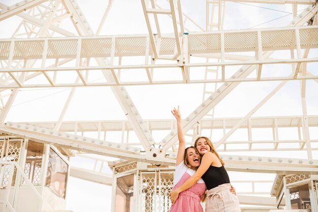 Two young women enjoying under the ferris wheel