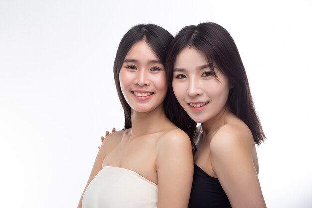 Two young women happily stood together from behind.