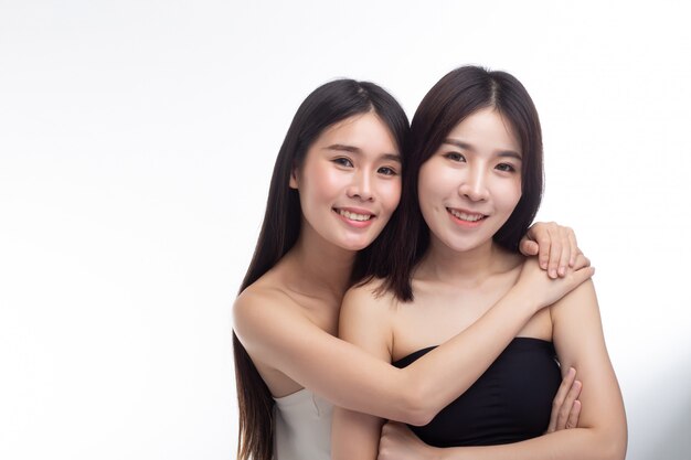 Two young women hug each other happily.