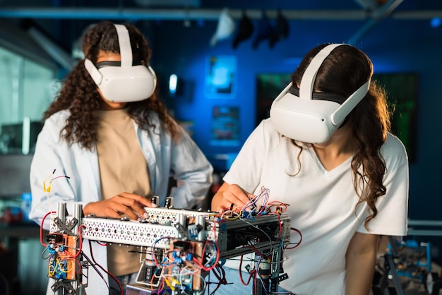 無料写真 研究室でロボット工学の実験をしている vr メガネをかけた 2 人の若い女性 テーブルの上のロボット