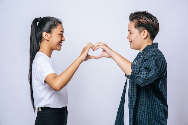 Two young women love each other hand mark heart shape.