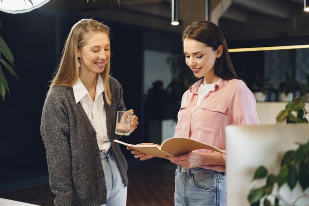 Two young women working together in office