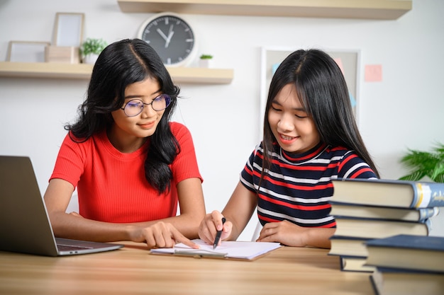 Two young women working with laptops lying on the table.