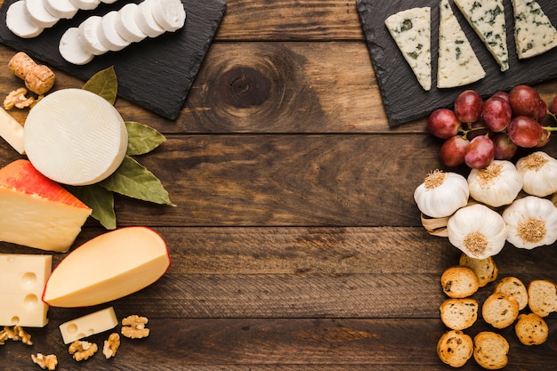 Types of cheese and ingredient on old wooden background