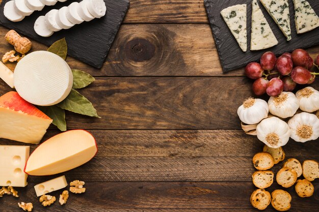 Types of cheese and ingredient on old wooden background