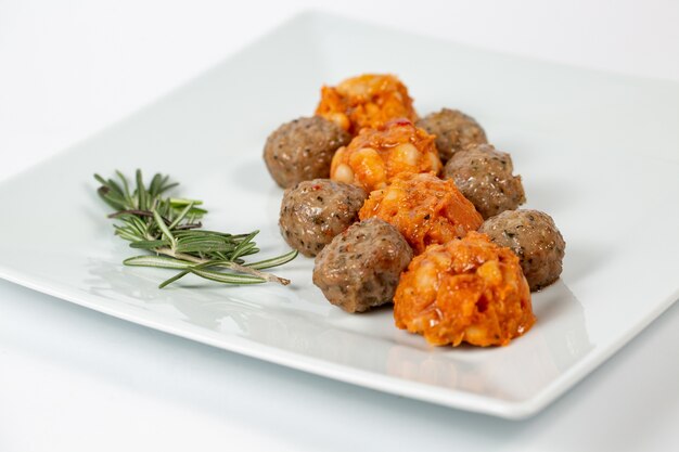 Types of meatballs on a white plate on white