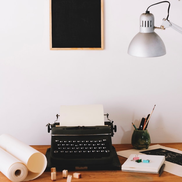 Typewriter and office supplies on table