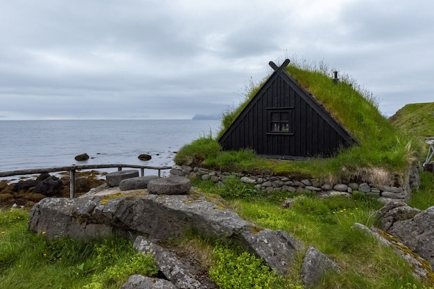 잔디 지붕 집과 생선 건조대가있는 전형적인 아이슬란드 어촌 마을