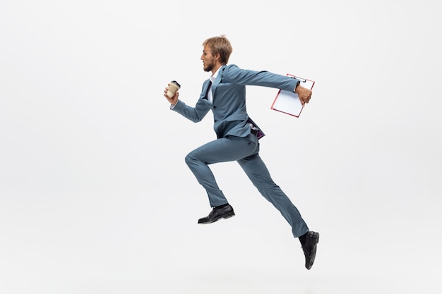 Typing. Man in office clothes running, jogging on white space like professional athlete, sportsman. Unusual look for businessman in motion, action with ball. Sport, healthy lifestyle, creativity.
