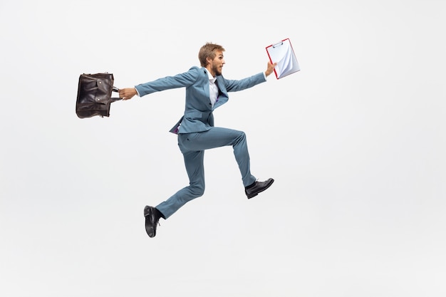 Typing. Man in office clothes running, jogging on white space like professional athlete, sportsman. Unusual look for businessman in motion, action with ball. Sport, healthy lifestyle, creativity.