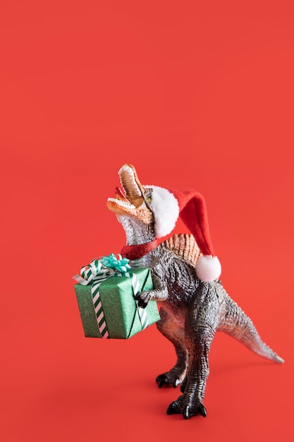 Free photo tyrannosaurus rex toy holding gift box