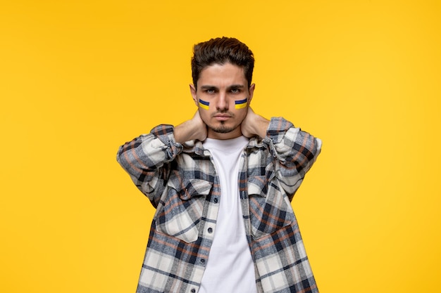 Ukraine russian conflict brave cute handsome guy with flags on cheeks holding neck angry