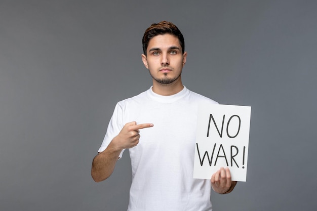 Free photo ukraine russian conflict cute handsome guy in white shirt with no war sign